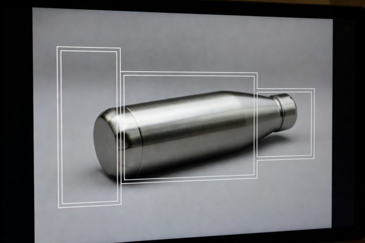 Cropped monitor screen displaying 9:16, 4:5, and 1:1 crop guide lines over a studio product photograph
