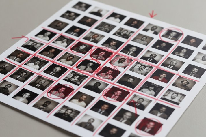 Close-up of a printed photographic contact sheet marked with a red grease pencil and crop lines